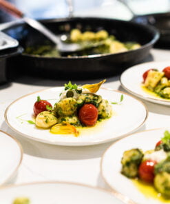 Plates of food on a table with a pan in the background