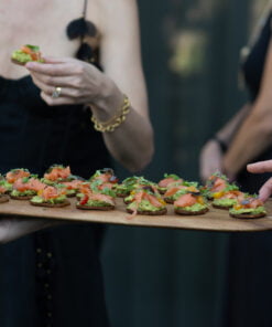 Person holding a tray of small appetizers with blurred background