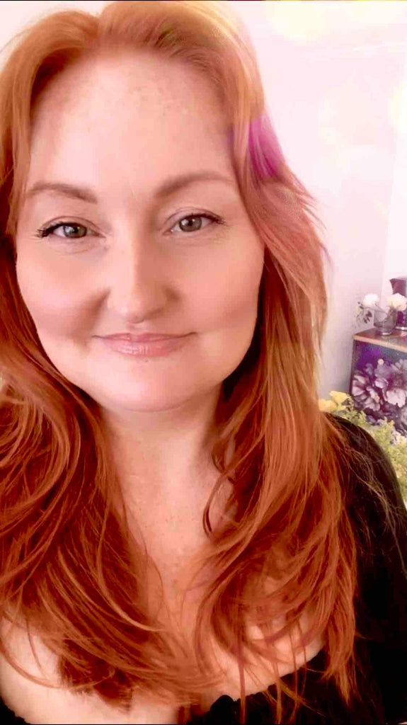 Woman with long, wavy hair smiling at the camera