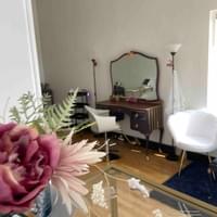Modern living room with a white armchair, coffee table, and decorative items.