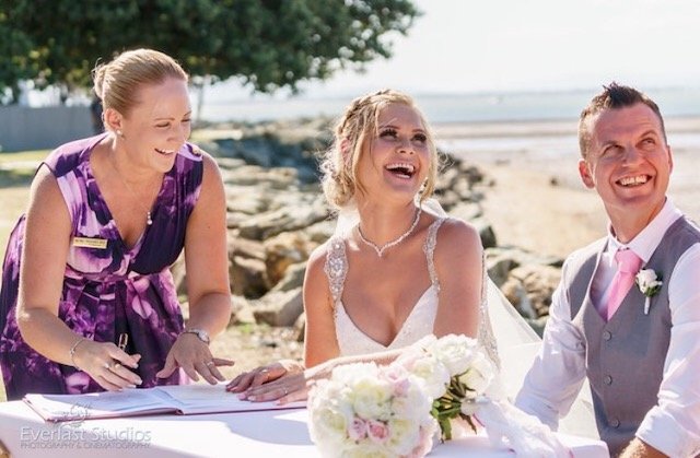 Wedding ceremony with a officiant, bride, and groom outdoors.