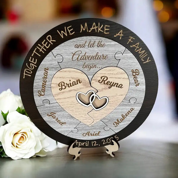 Personalized wooden plaque with engraved names and dates, placed on a stand with white roses in the foreground.