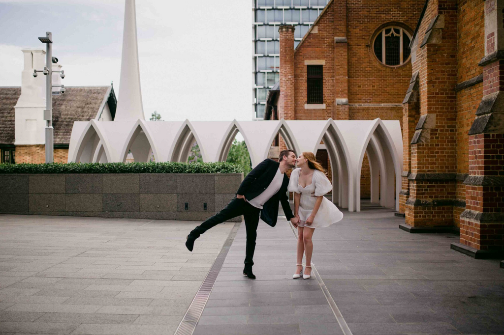 Couple posing on a rooftop with architectural background