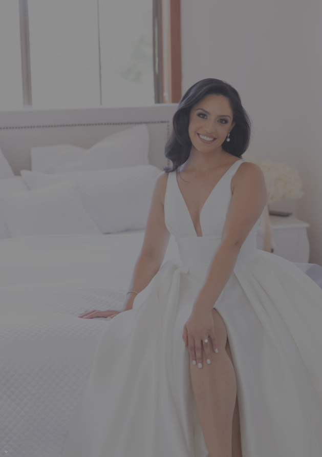 Woman in a white dress standing in a bedroom