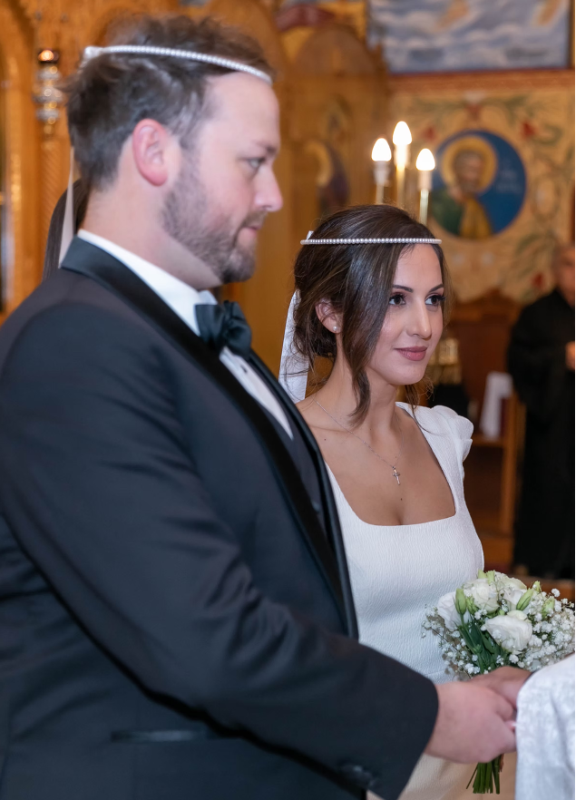 Man and woman in formal attire with a decorative background